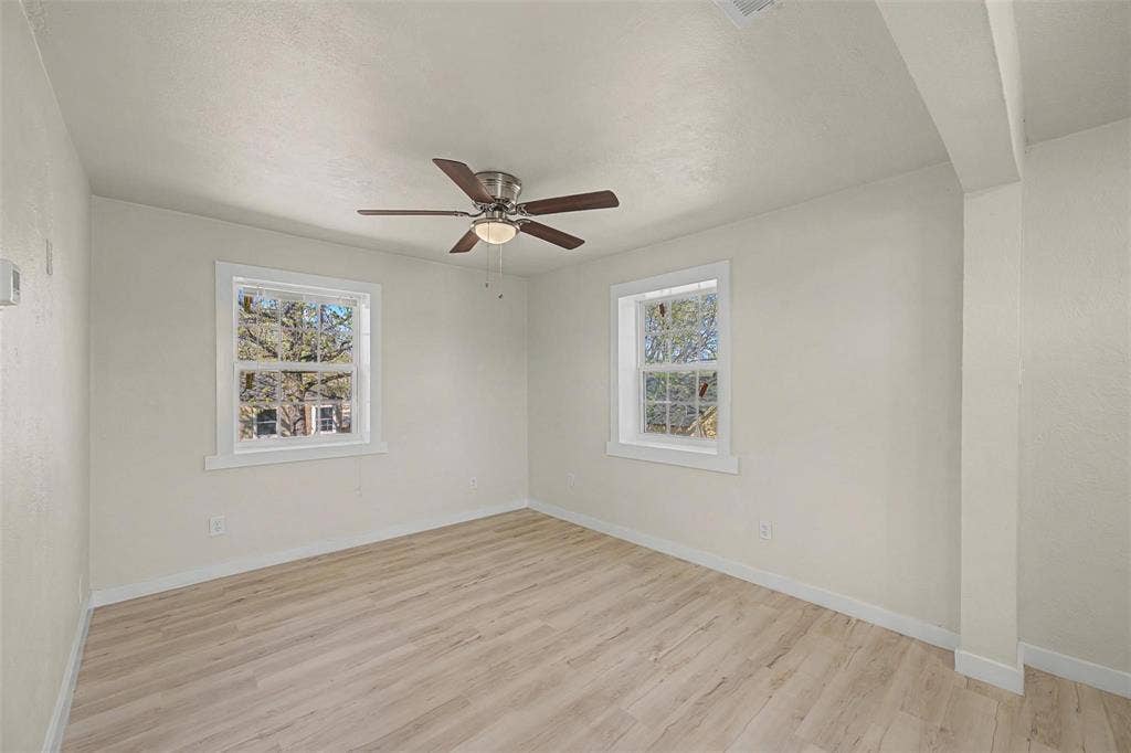 9021 White Settlement Road, #D, White Settlement, TX 76108 Bright interior room featuring light wood-finish flooring, white walls, and a ceiling fan with integrated lighting
