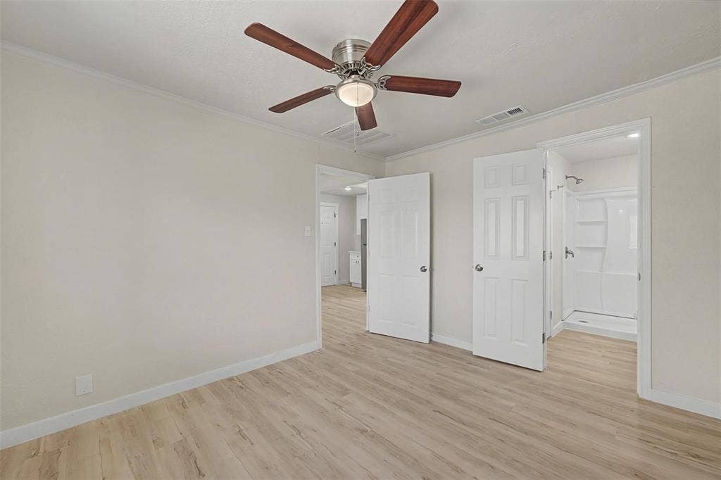 9021 White Settlement Road, #D, White Settlement, TX 76108 Light wood-finish flooring extending into an en-suite bathroom featuring a walk-in shower with a white surround
