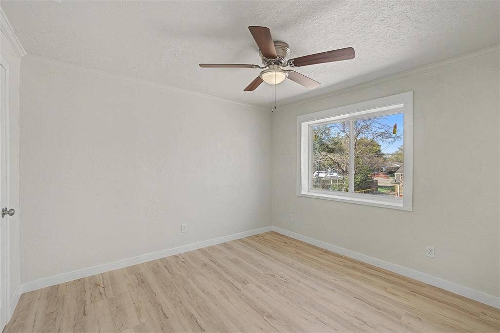 9021 White Settlement Road, #D, White Settlement, TX 76108 Room with wood-finish flooring, light-toned walls, and a ceiling fan with integrated lighting