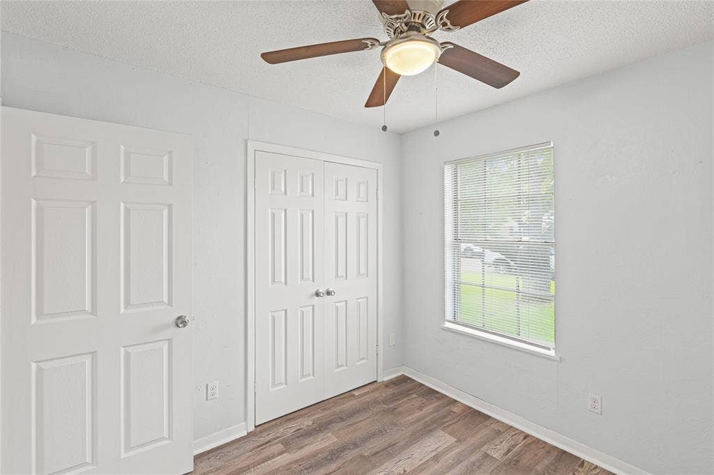 3407 Highmeadow Lane, Greenville, TX 75402 Interior space featuring wood-finish flooring, a white window with blinds, and a ceiling fan with integrated lighting