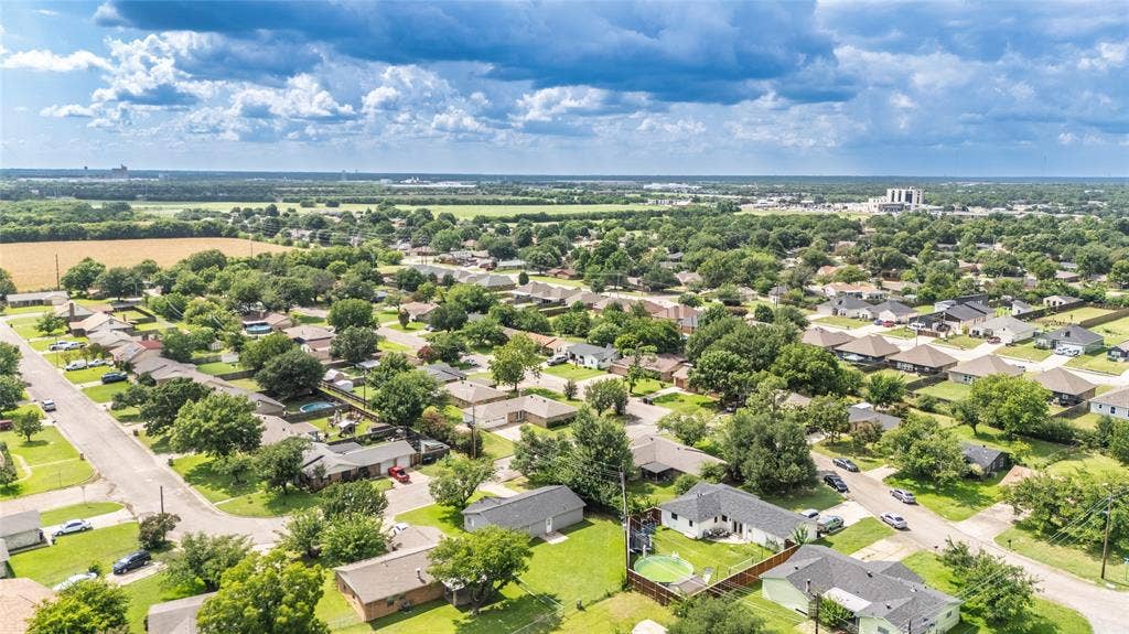 3407 Highmeadow Lane, Greenville, TX 75402 Aerial perspective showcasing a residential area with mature trees and a structured street layout