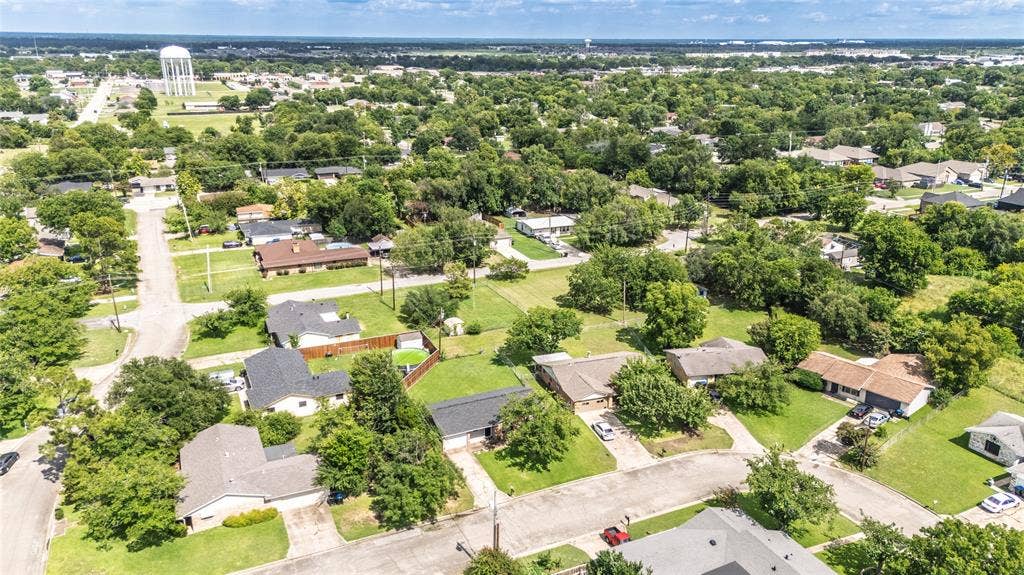 3407 Highmeadow Lane, Greenville, TX 75402 Expansive residential area featuring numerous mature trees and a water tower in the distance
