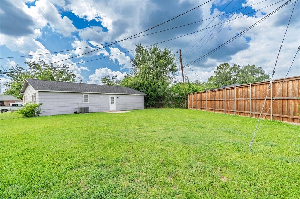 3407 Highmeadow Lane, Greenville, TX 75402 Expansive green lawn with a solid wood privacy fence