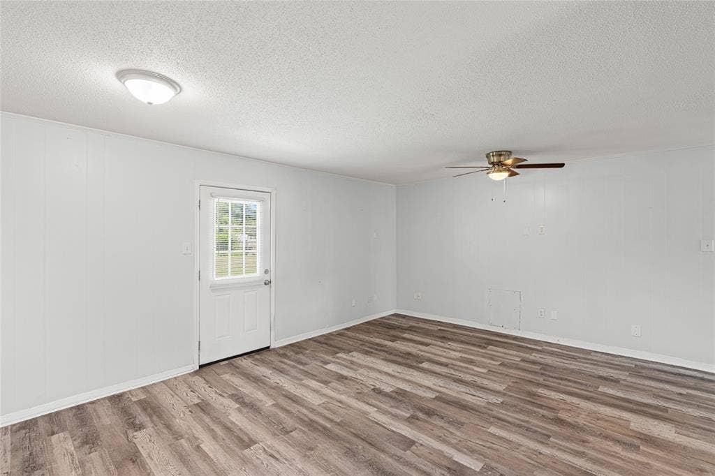 3407 Highmeadow Lane, Greenville, TX 75402 Spacious room featuring wood-finish flooring and white walls