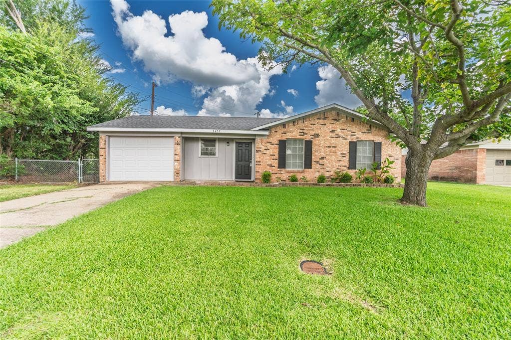 3407 Highmeadow Lane, Greenville, TX 75402 Brick and siding exterior with a single-car garage and mature front yard tree