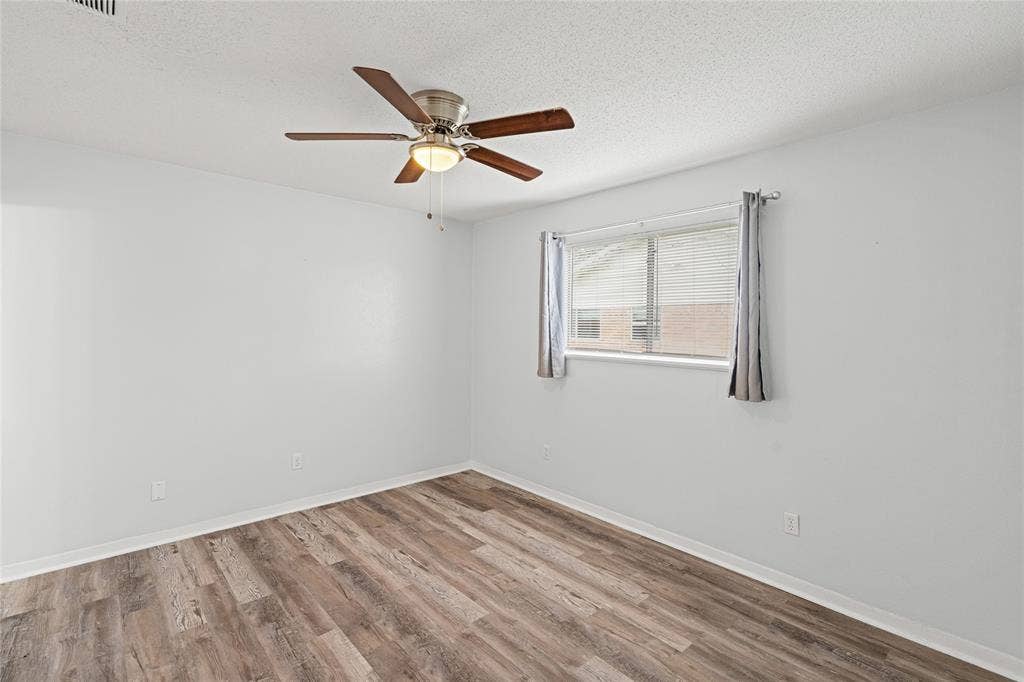 3407 Highmeadow Lane, Greenville, TX 75402 Spacious room featuring wood-finish flooring and a ceiling fan with integrated lighting