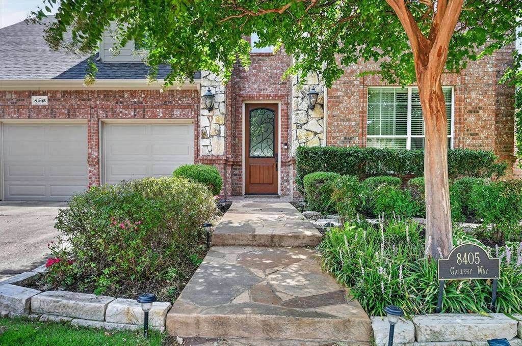 8405 Gallery Way, McKinney, TX 75072 Brick and stone facade featuring a decorative wood entry door with wrought iron detailing