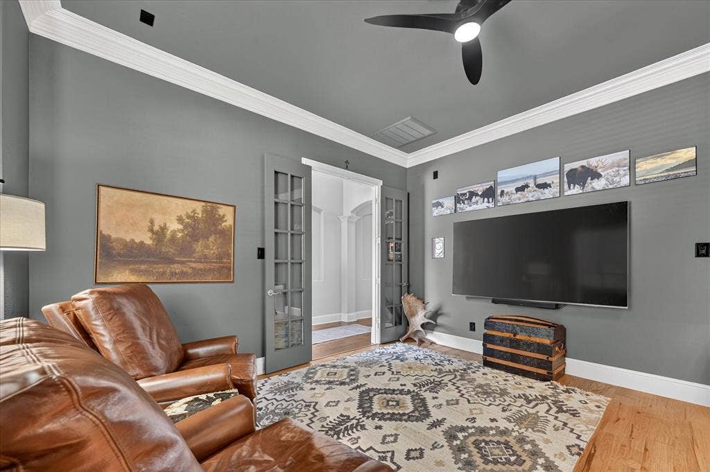 8405 Gallery Way, McKinney, TX 75072 Hardwood flooring extending throughout, French doors with glass panels, crown molding, and a ceiling fan with integrated lighting