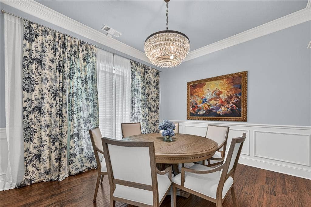 8405 Gallery Way, McKinney, TX 75072 Formal dining space featuring dark wood-finish flooring, an ornate crystal chandelier, and detailed white crown molding