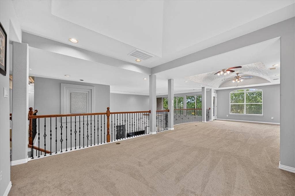 8405 Gallery Way, McKinney, TX 75072 Expansive carpeted loft area featuring a decorative wrought iron and wood-finish railing