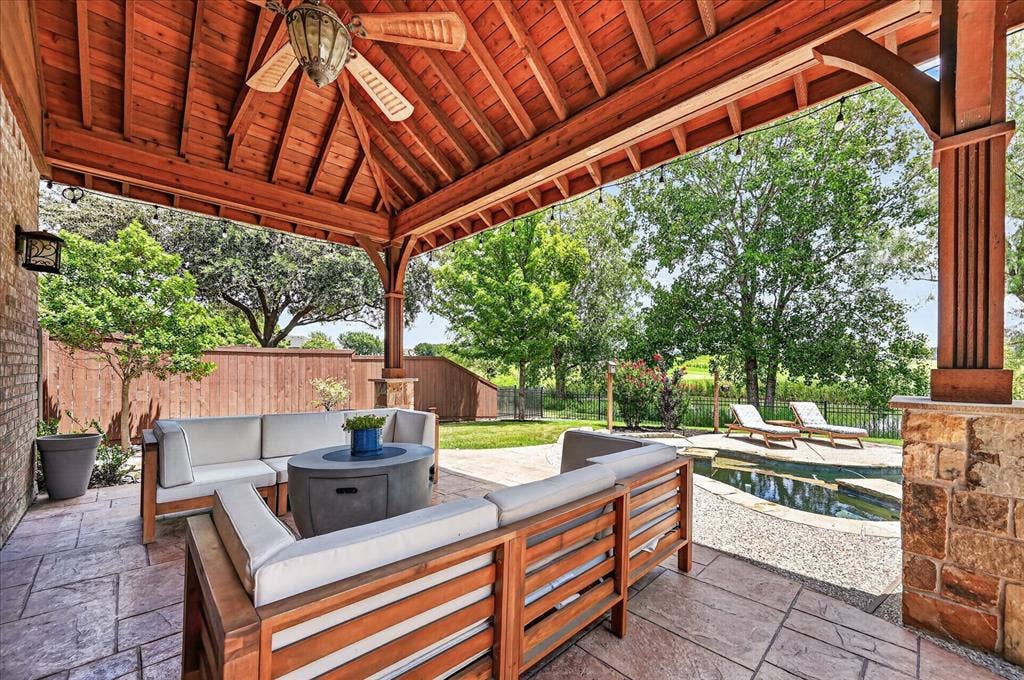 8405 Gallery Way, McKinney, TX 75072 Covered patio featuring a wood-plank ceiling with a ceiling fan, stamped concrete flooring, and stone pillars