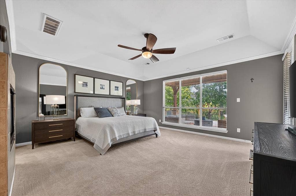 8405 Gallery Way, McKinney, TX 75072 Spacious bedroom featuring neutral carpeting, tray ceiling with a ceiling fan, and extensive window-line with blinds