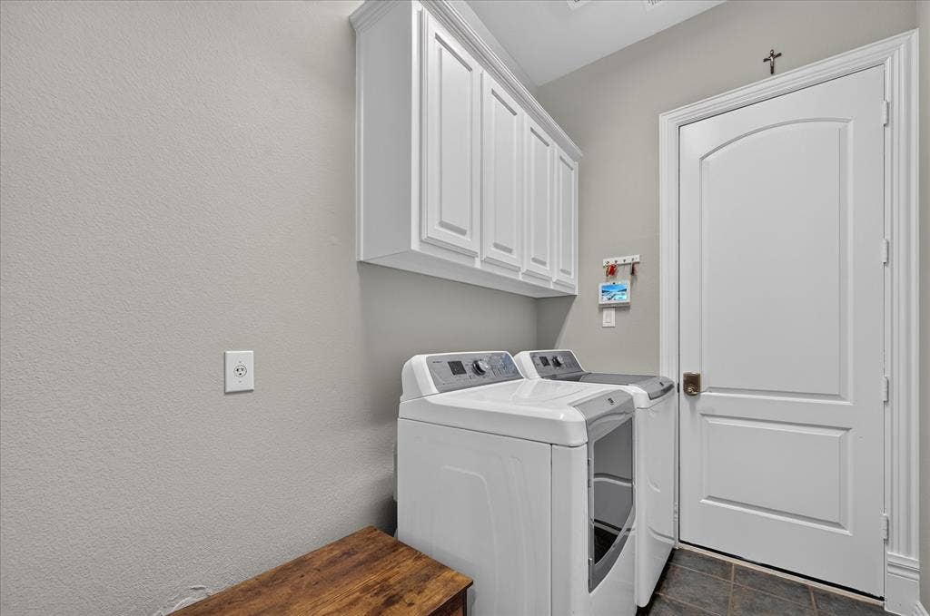 8405 Gallery Way, McKinney, TX 75072 Laundry area featuring overhead white cabinetry with crown molding, durable tile flooring, and a white arched panel door