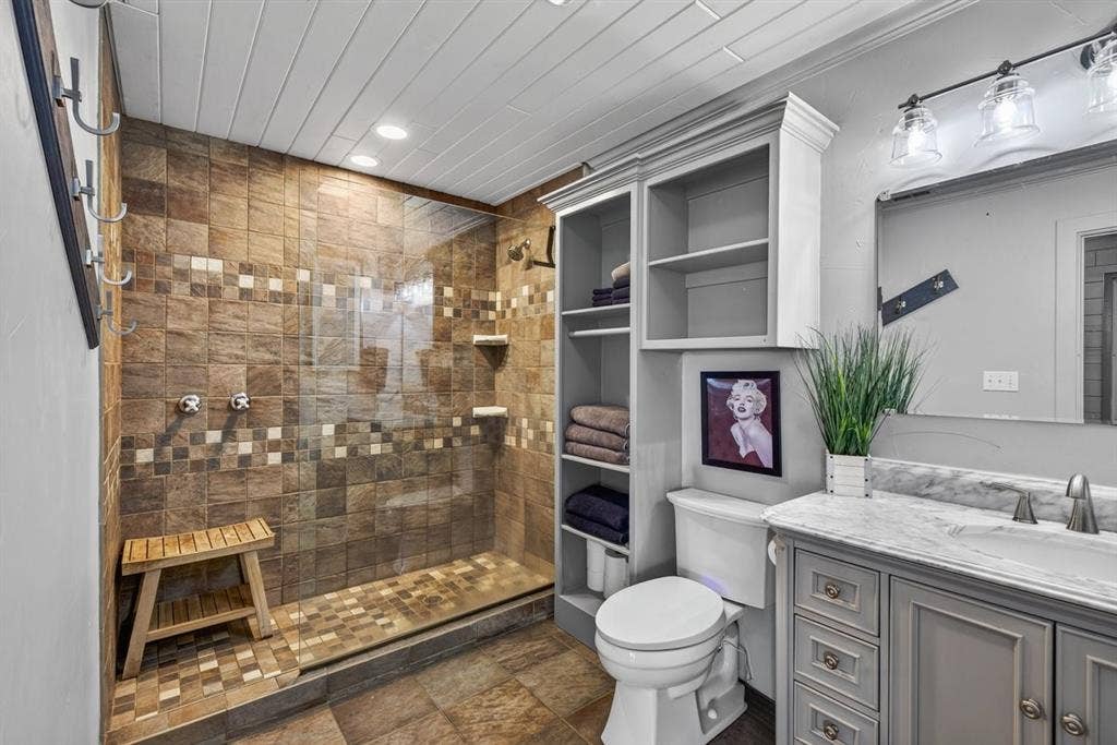 18251 Rocky Point Run, Mabank, TX 75156 Warm natural stone style shower in primary bedroom.