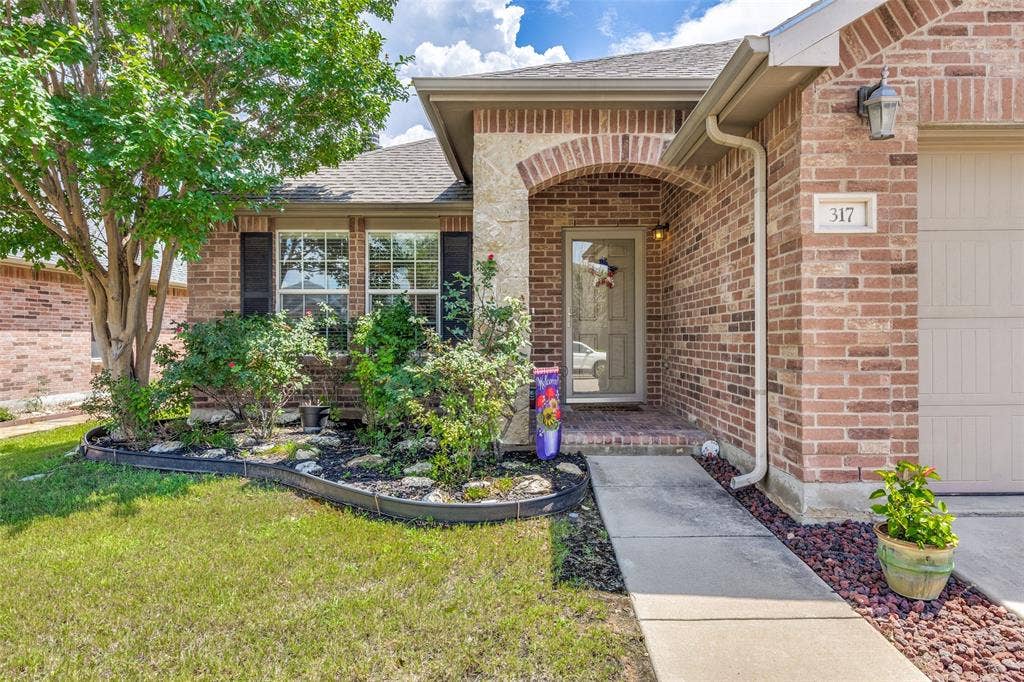 317 Amethyst Drive, Fort Worth, TX 76131 Brick and stone facade featuring an arched entryway