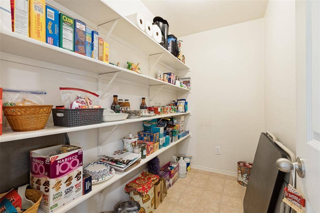 317 Amethyst Drive, Fort Worth, TX 76131 Walk-in pantry featuring extensive shelving, light-colored walls, and tile flooring