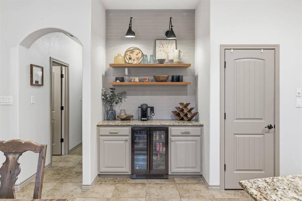 8040 Branch Hollow Trail, Fort Worth, TX 76123 Custom bar with tile wall to ceiling, drink refrigerator, exposed wood shelves, and gorgeous lighting!