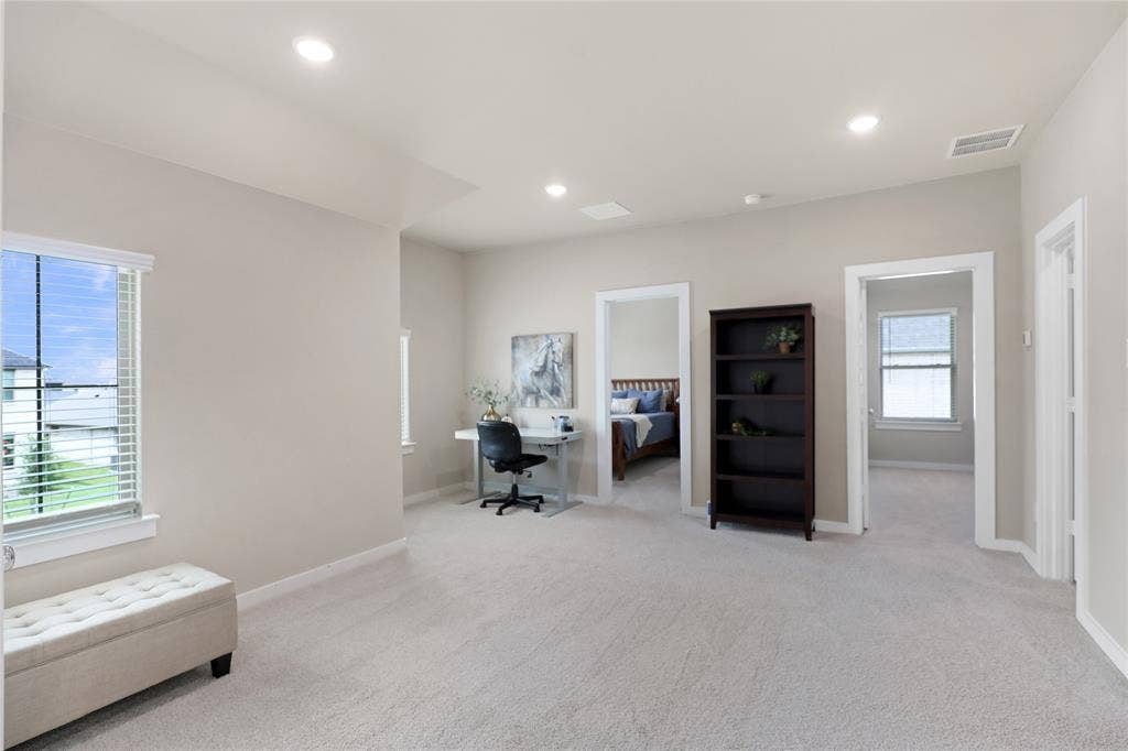 919 Edgehurst Drive, Princeton, TX 75071 Spacious open concept room with light-colored carpeting, multiple doorways, recessed lighting, and a window with horizontal blinds