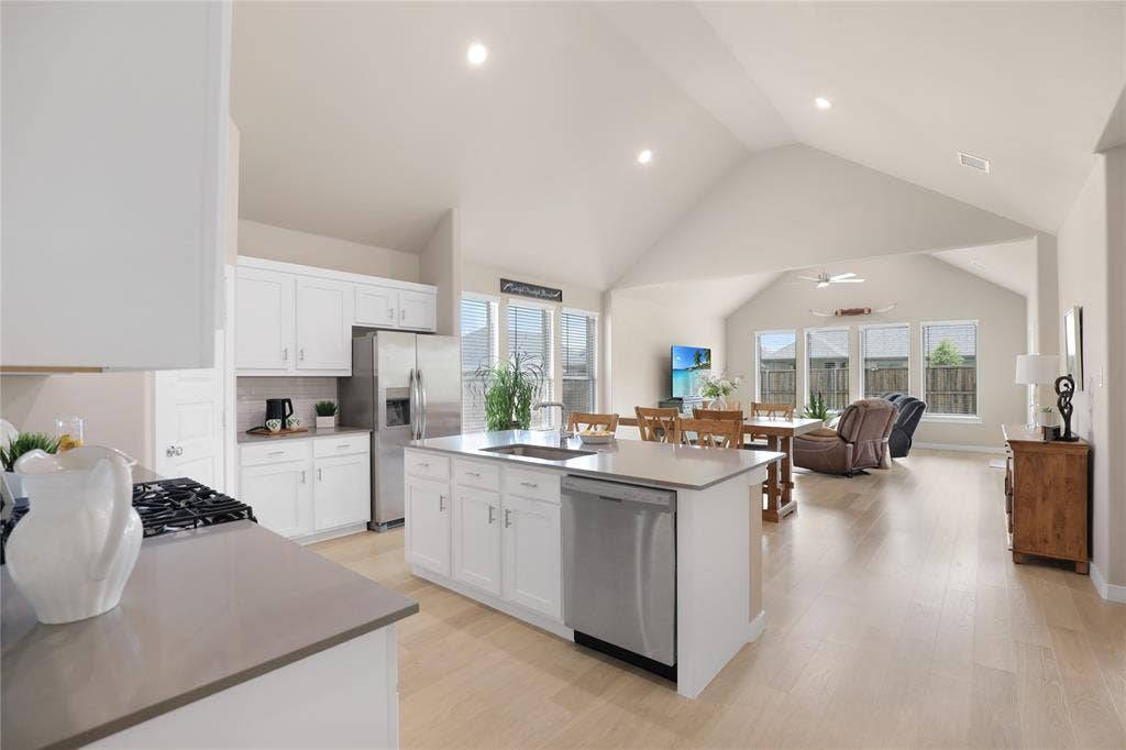 919 Edgehurst Drive, Princeton, TX 75071 Kitchen featuring white cabinetry, a center island with sink, stainless steel appliances, and light wood-finish flooring