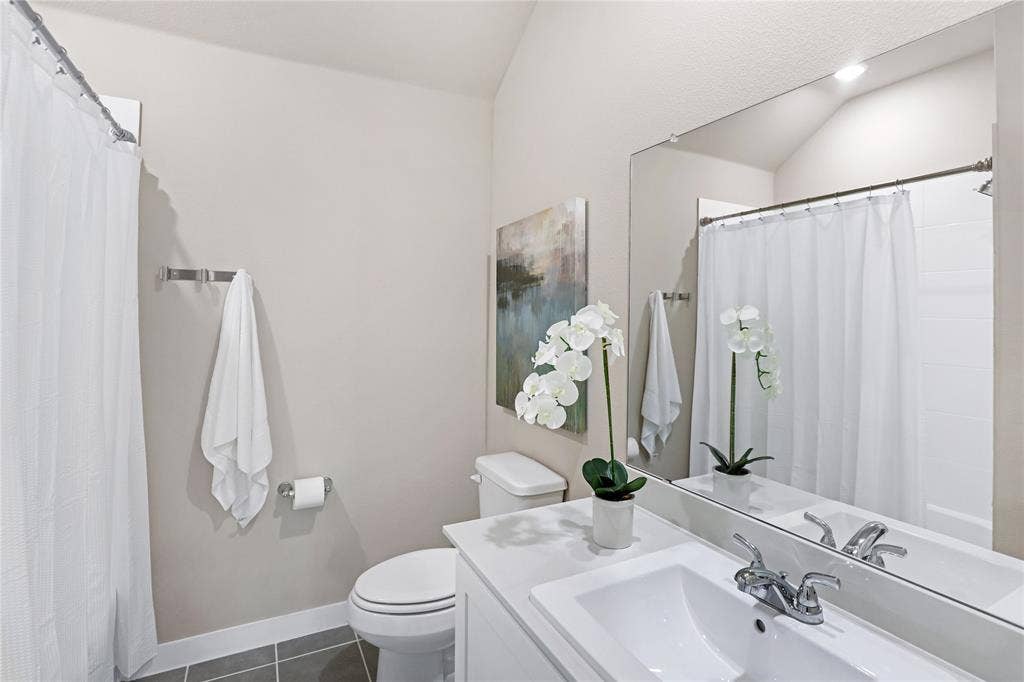 919 Edgehurst Drive, Princeton, TX 75071 Bathroom featuring a white vanity with integrated sink, chrome faucet, and a large wall-mounted mirror