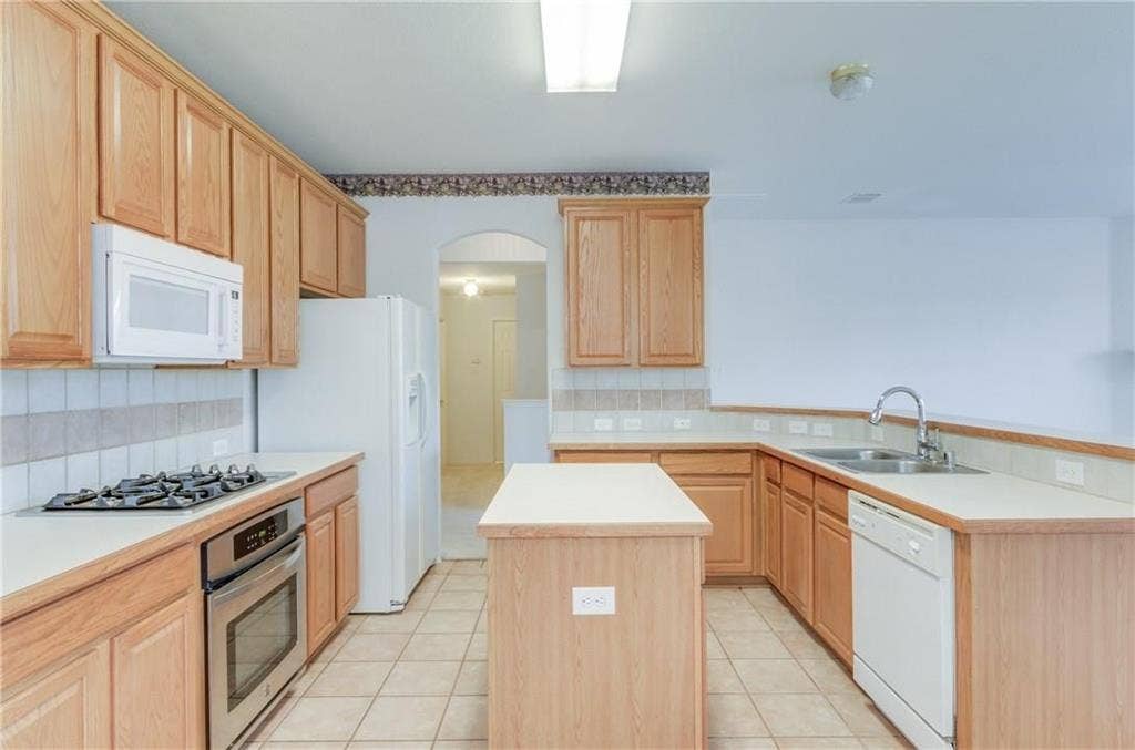 4440 Waskom Drive, Plano, TX 75024 Kitchen featuring abundant wood cabinetry, light-toned countertops, a tile backsplash, and a built-in stainless steel oven with a gas cooktop
