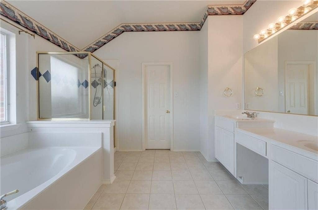 4440 Waskom Drive, Plano, TX 75024 Spacious bathroom featuring a built-in tub, separate shower with framed glass enclosure, and dual vanity with integrated countertop