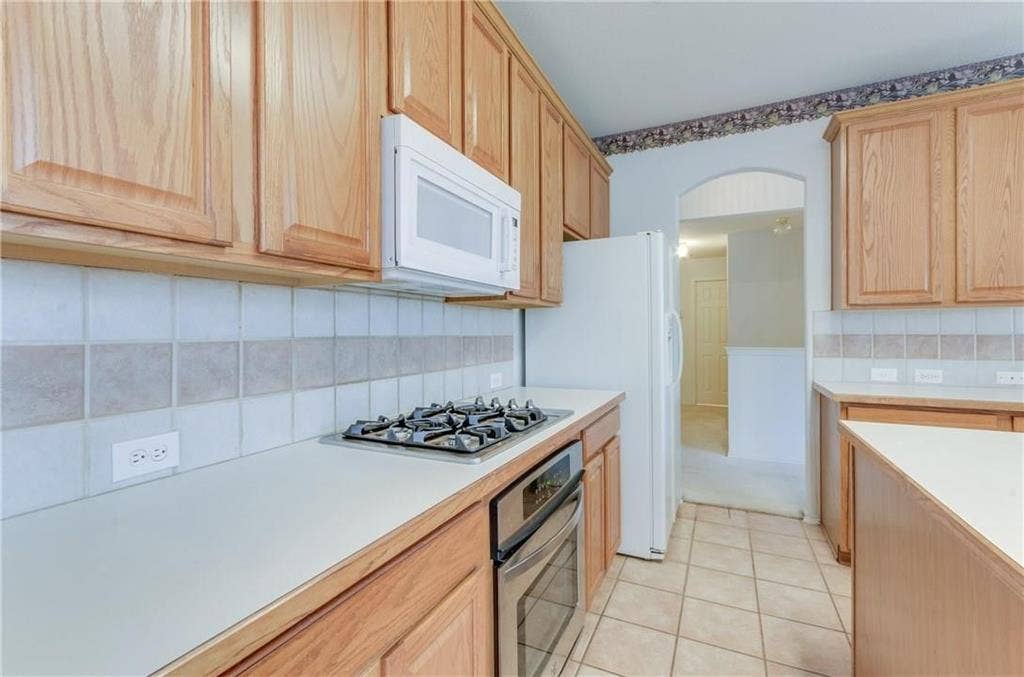 4440 Waskom Drive, Plano, TX 75024 Kitchen featuring light wood cabinetry, a built-in gas cooktop, and a wall-mounted microwave