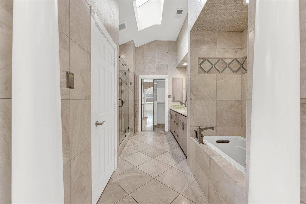 An angled ceiling skylight pours brilliant natural light down the center of this tiled corridor. Start your day feeling instantly refreshed as morning sunshine energizes your early routine.