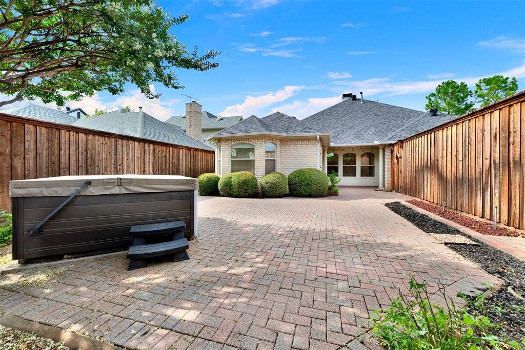 The secure perimeter fencing provides a handsome frame that accentuates the home's classic light-brick architecture. Imagine enjoying a relaxing evening retreat under the stars, feeling completely tucked away from the rest of the world.