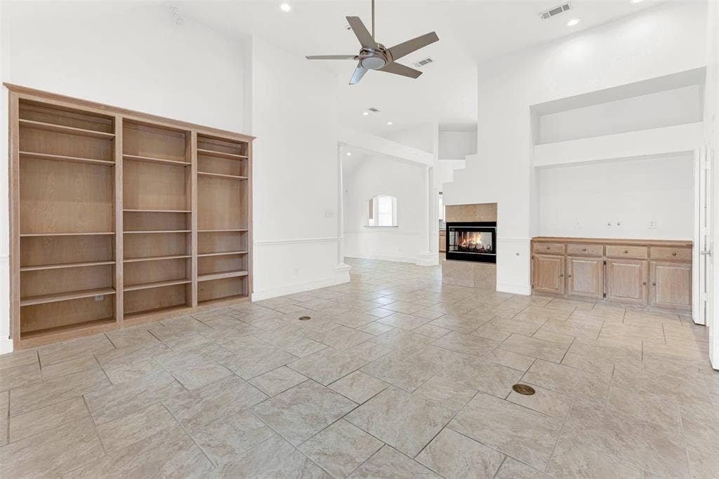 A massive, custom-built wooden bookcase anchors the room, drawing the eye up toward the lofty high peak. Imagine displaying your favorite novels and travel treasures here, creating an inspiring backdrop for your daily quiet time.