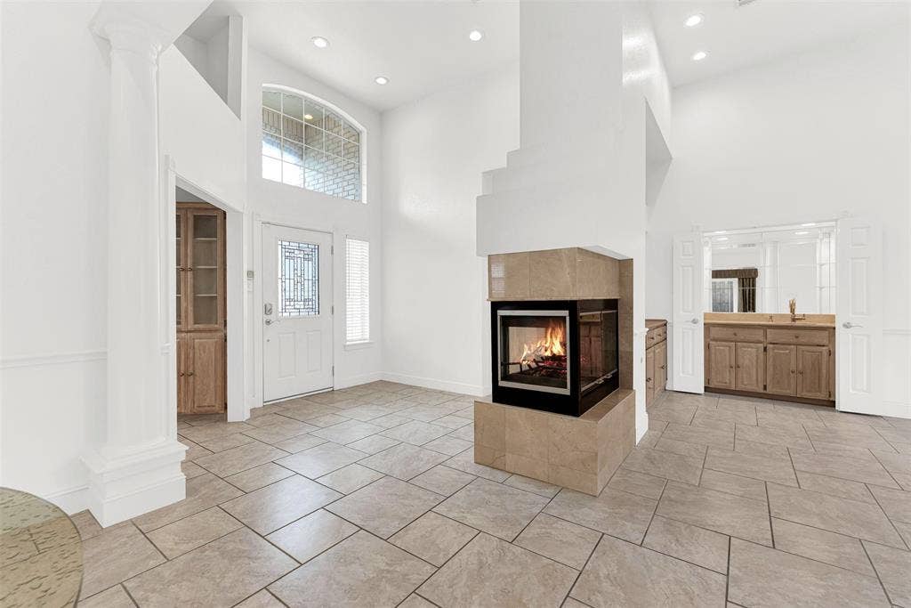 A high-set transom window above the main entrance bathes the entire two-story foyer in brilliant sunshine. It creates a cheerful, sophisticated first impression for friends arriving to celebrate a special occasion.