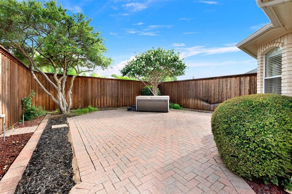 Richly toned herringbone pavers catch the bright midday sun, creating a warm and grounded outdoor escape. Picture stepping outside into this private oasis for a breath of fresh air and a peaceful mid-afternoon break.