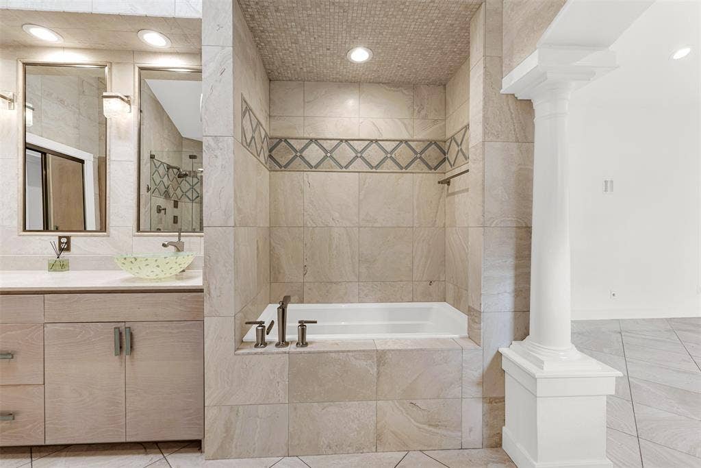 A deep soaking tub is nestled into an intimate tiled alcove accented with diamond-patterned trim. Draw a warm bath at twilight and let the worries of the workweek melt away in your private grotto.