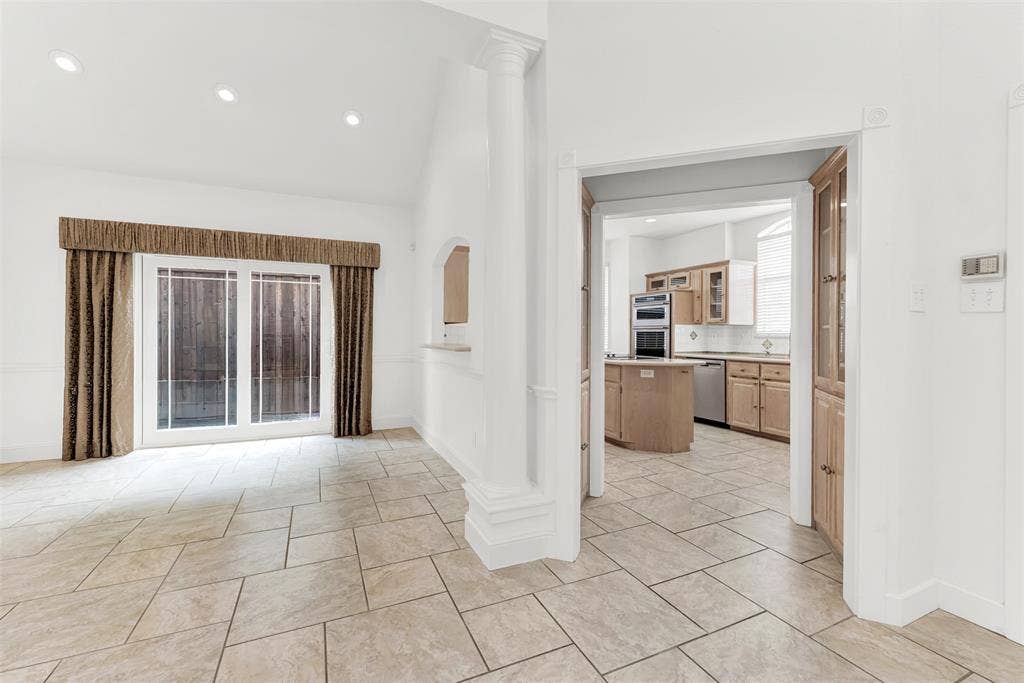 A stately white column dramatically frames the open transition into the sun-drenched culinary heart of the home. Enjoy a seamless flow as you carry appetizers from the kitchen to the bright dining area to welcome arriving guests.
