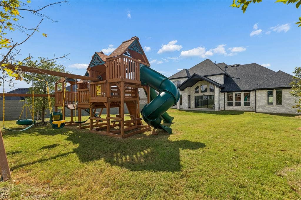 1908 Breezy Brook Lane, Argyle, TX 76226 Huge backyard with a playset, swing set, and backyard jungle gym