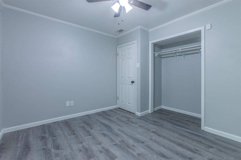 Room featuring grey wood-finish flooring, light grey walls, and white trim