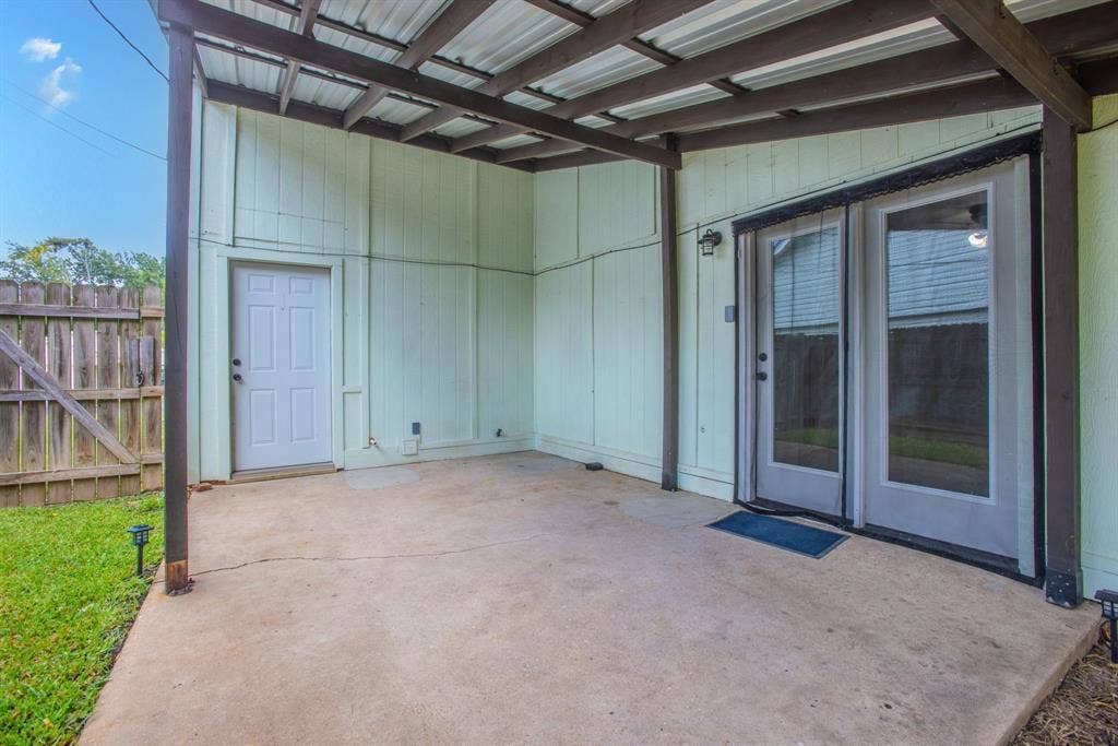 Covered patio with a corrugated metal roof, providing an outdoor living area