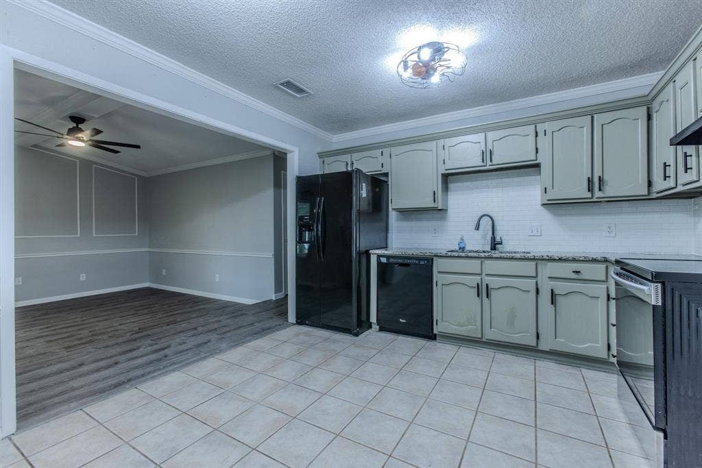 Kitchen featuring light gray cabinetry, black appliances, white subway tile backsplash, and granite-style countertops