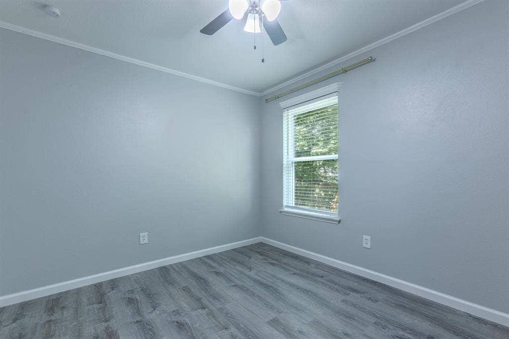 Neutral-toned interior with wood-finish flooring, a ceiling fan with light fixture, and window blinds