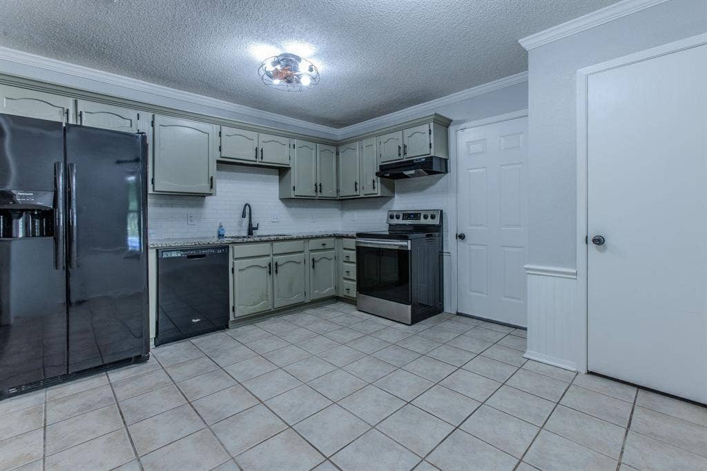 Kitchen featuring light green cabinetry, tile backsplash, and granite-style countertops