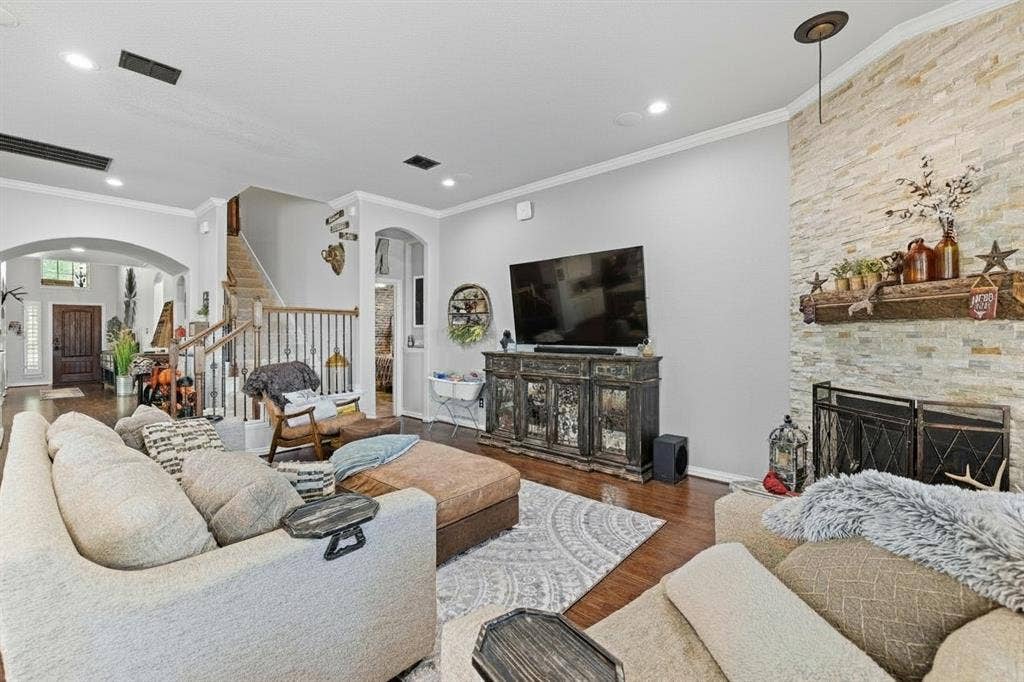 12012 Tobosa Circle, McKinney, TX 75071 Living room with hardwood-finish flooring, recessed lighting, and a stone-clad fireplace featuring a wood mantle