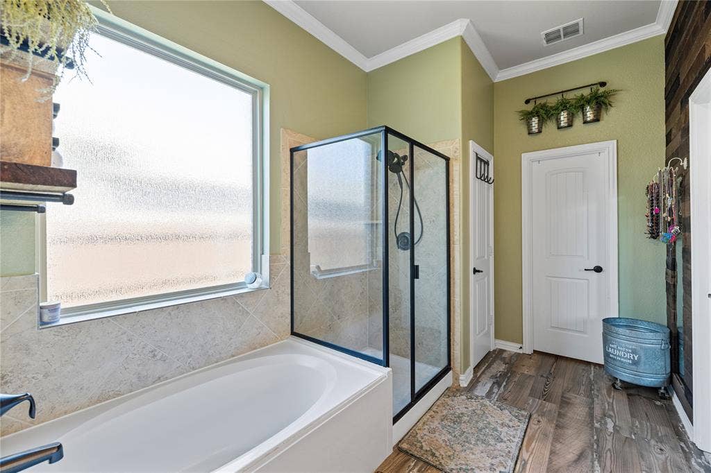12012 Tobosa Circle, McKinney, TX 75071 Bathroom with ornamental molding, plenty of natural light, separate shower and tub, and hardwood / wood-style floors