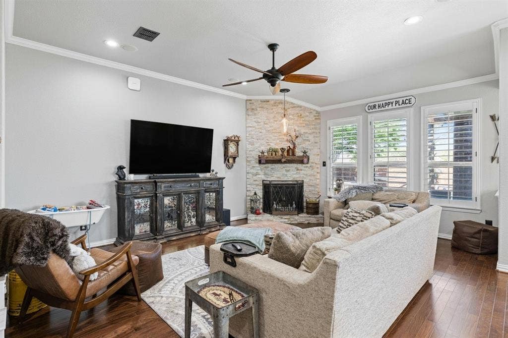 12012 Tobosa Circle, McKinney, TX 75071 Living area featuring a corner fireplace with a stone surround and wood mantel