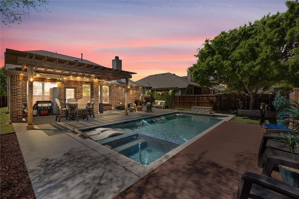 12012 Tobosa Circle, McKinney, TX 75071 Pool at dusk featuring a patio area, an in ground hot tub, a wooden deck, and a pergola
