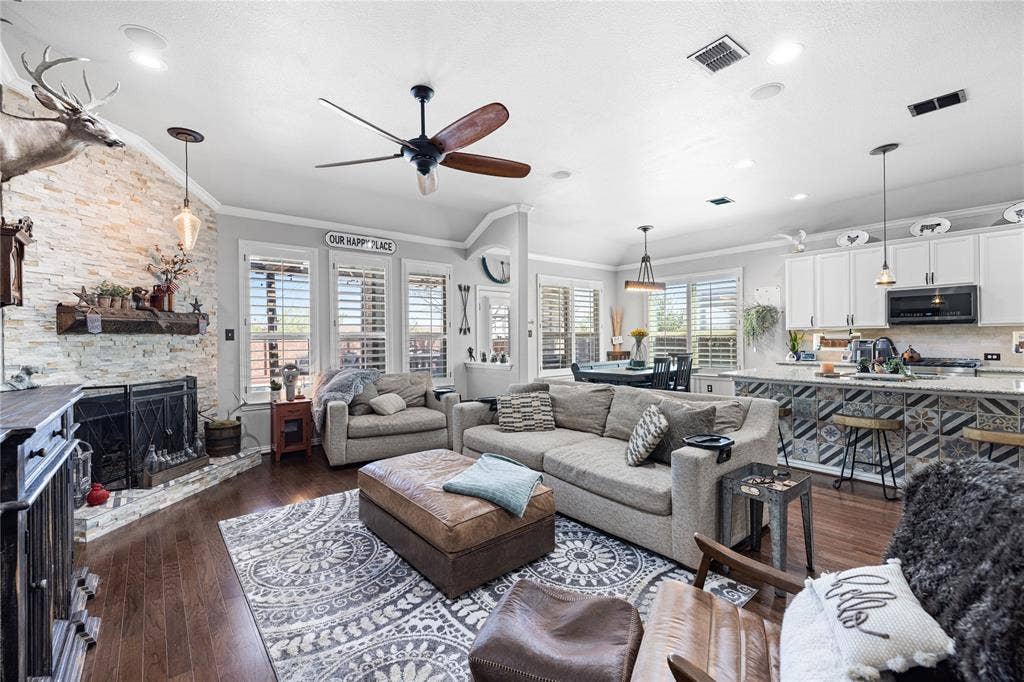 12012 Tobosa Circle, McKinney, TX 75071 Living room featuring ornamental molding, ceiling fan, a wealth of natural light, and dark hardwood / wood-style floors