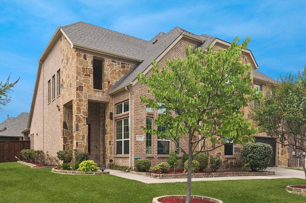 1650 Chisholm Trail, Prosper, TX 75078 Two-story residence featuring a brick and stone exterior, gabled roofline, and attached garage