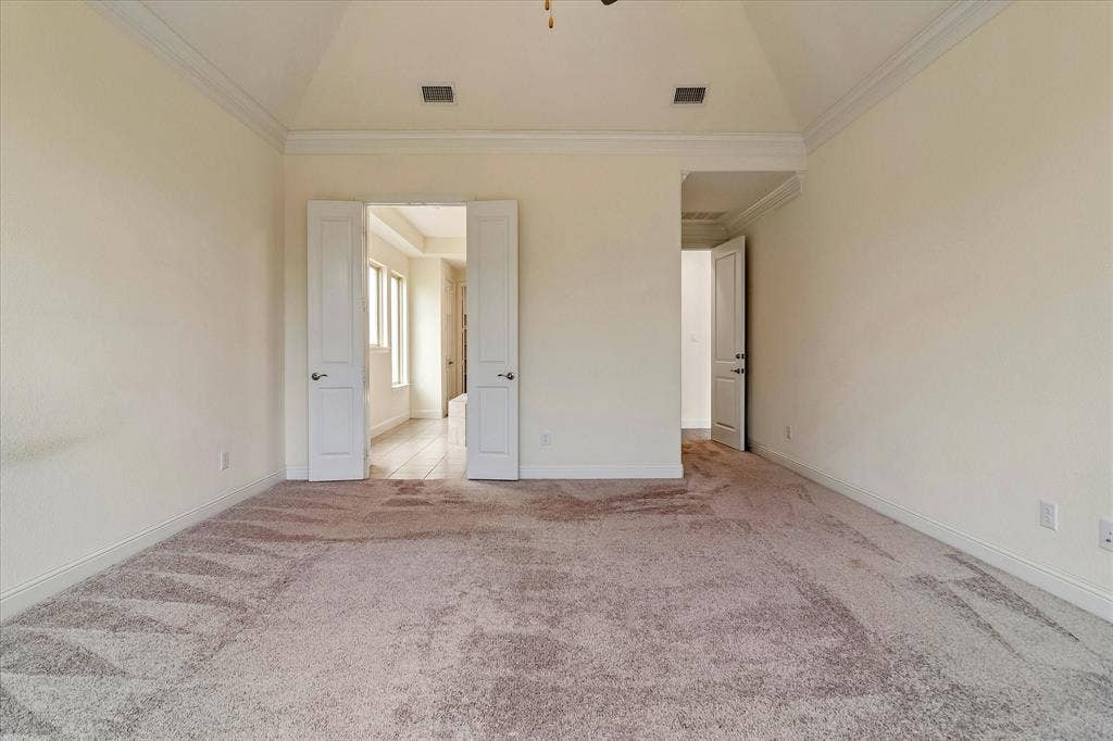 1650 Chisholm Trail, Prosper, TX 75078 Spacious room featuring vaulted ceilings, crown molding, and neutral-toned carpeting