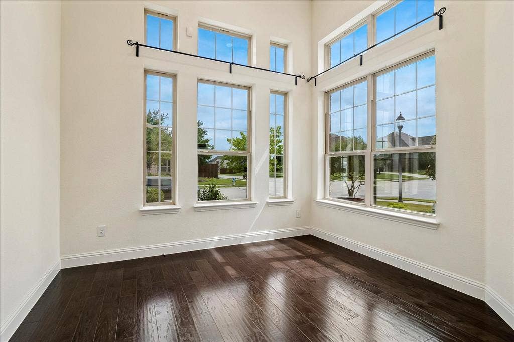1650 Chisholm Trail, Prosper, TX 75078 Two-story window arrangement with transom windows, dark wood-finish flooring, white baseboards, and white wall finishes