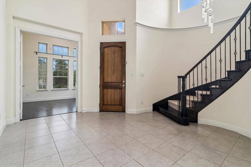 1650 Chisholm Trail, Prosper, TX 75078 Grand foyer featuring light-toned tile flooring and a dark wood front door with a transom window
