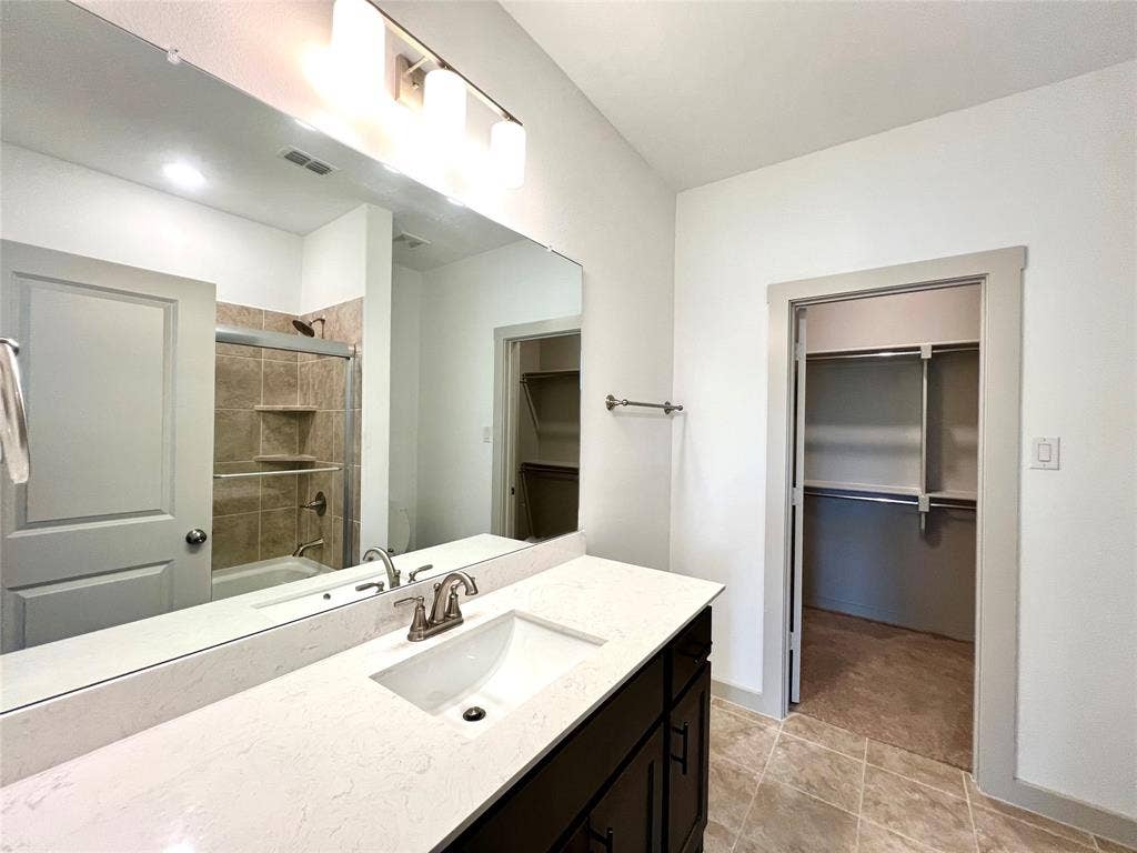 1755 Montgomery Drive, Plano, TX 75075 Bathroom featuring tile patterned flooring, vanity, and combined bath / shower with glass door